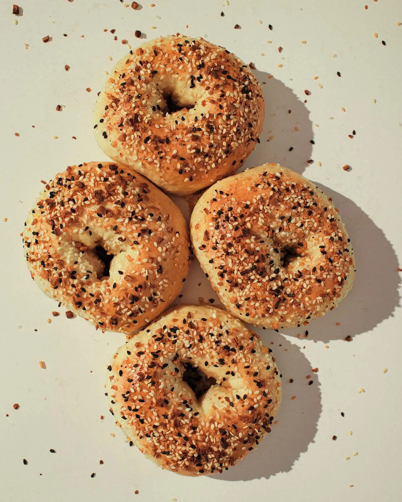 Four everything bagels arranged together, ready to bag.