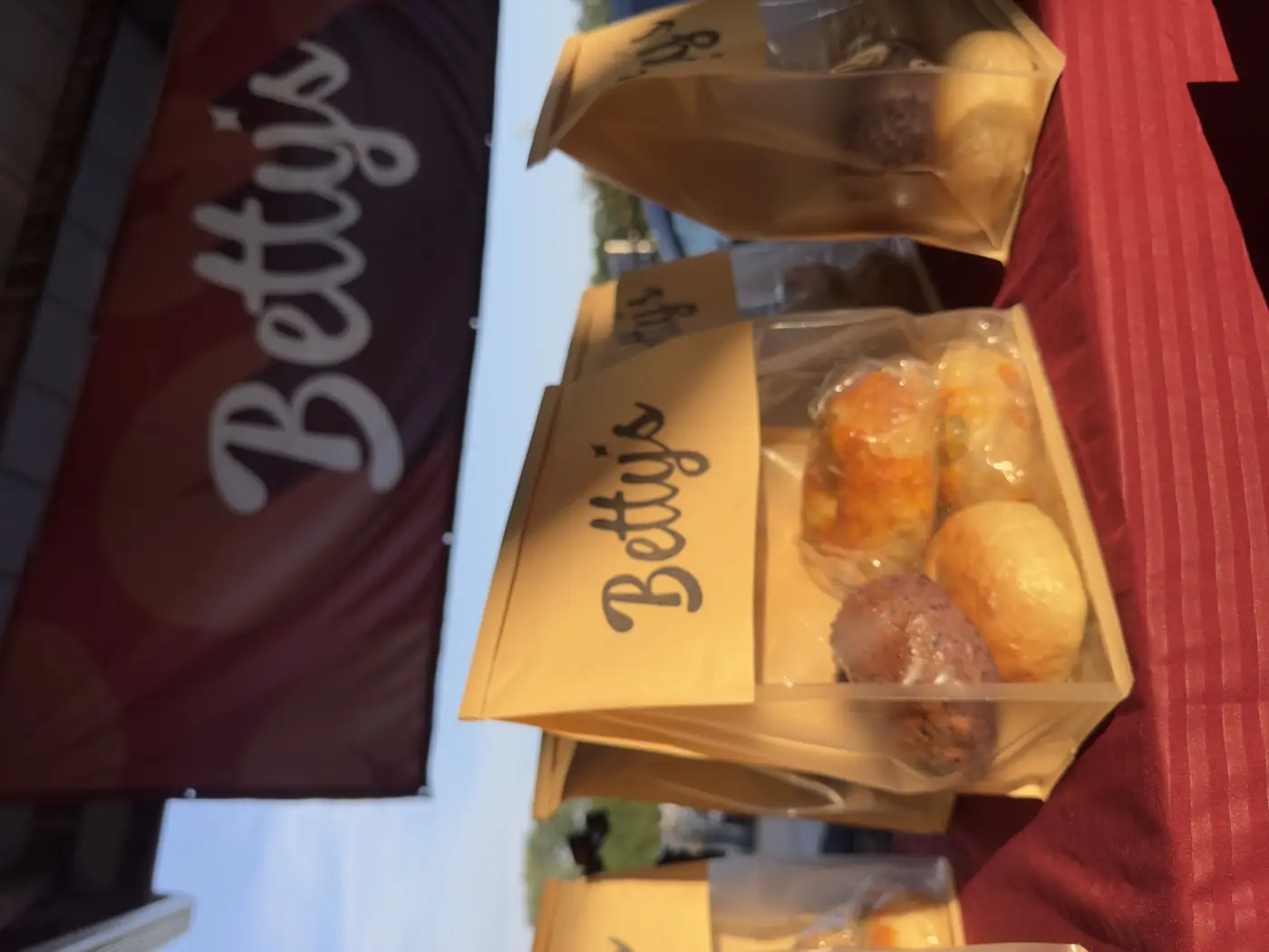 Bags of Betty's bagels on the stall table in early morning light.